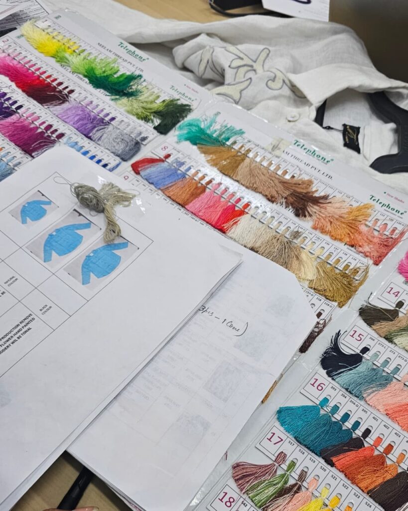 Embroidery thread shade cards beside a design spec